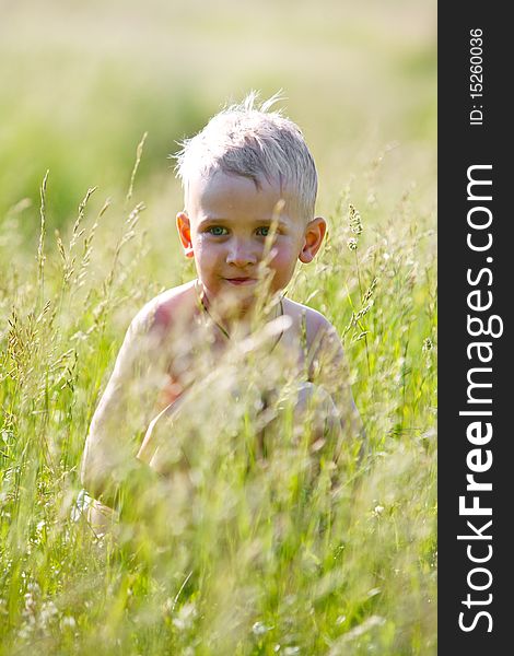 Boy hiding in the field after bathing in the river. Boy hiding in the field after bathing in the river