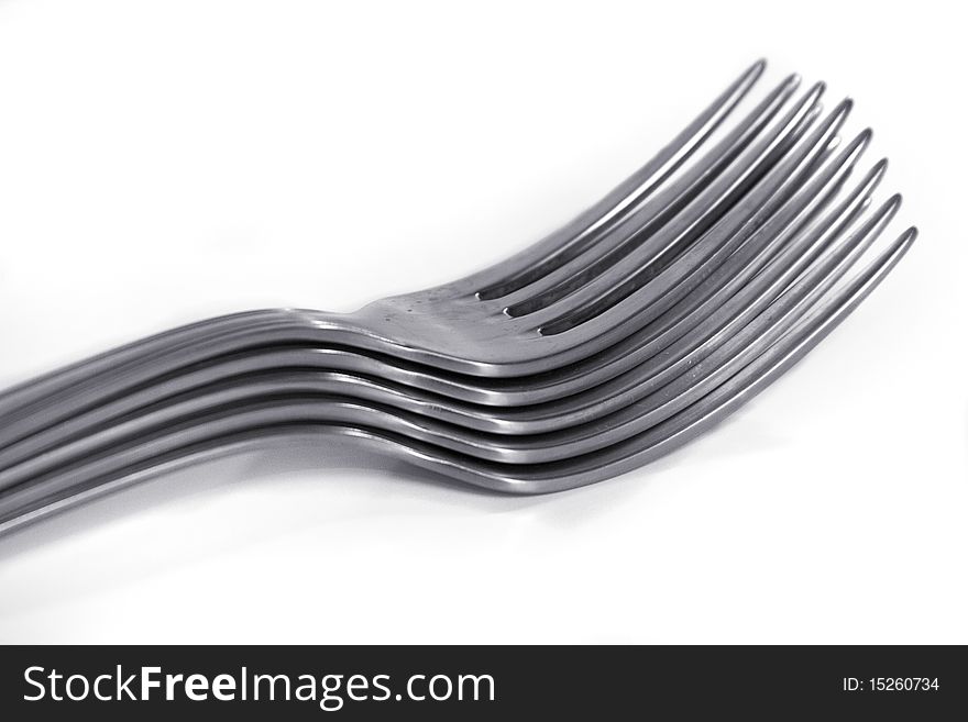 An image of 5 piled forks over a white background