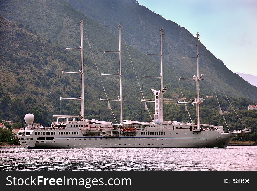 Cruise ship in a bay with mountains in background