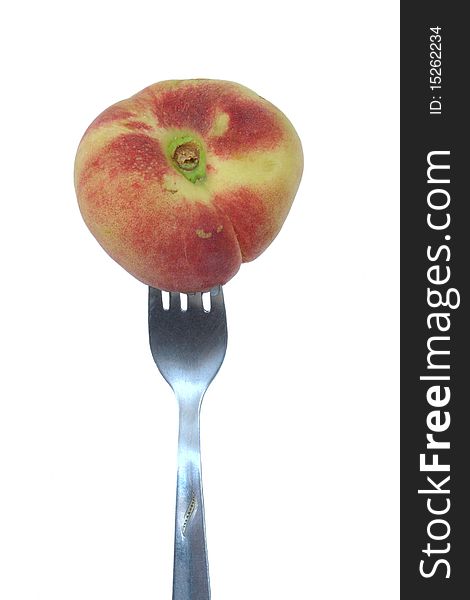 Peach (paraguaya) on the fork in isolated over white
