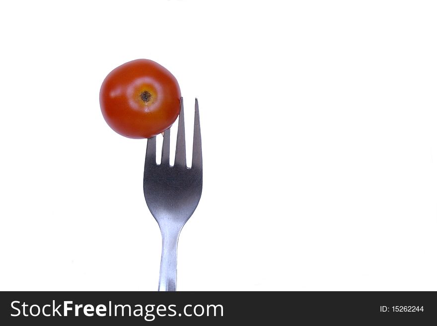 Tomato cherry on fork in isolated over white. Tomato cherry on fork in isolated over white