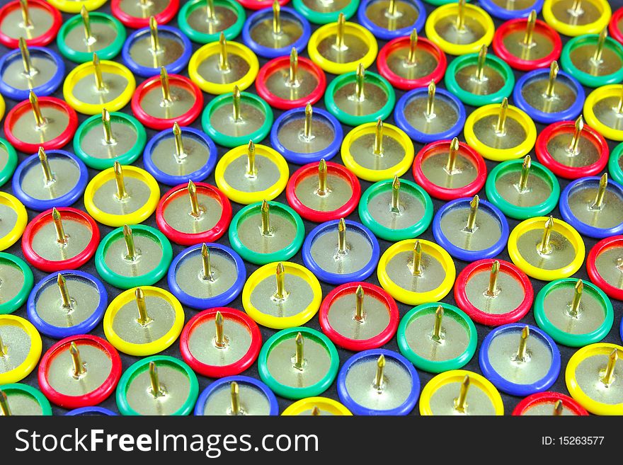 A group of colored drawing pins in formation