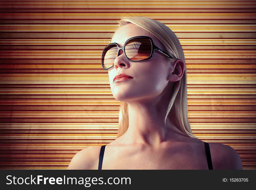 Beautiful woman wearing sunglasses with colouresd stripes on the background. Beautiful woman wearing sunglasses with colouresd stripes on the background