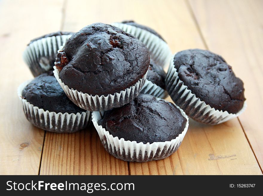 Delicious cocoa and banana muffins on a wooden table