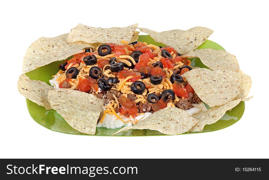 Taco dip with tortilla chips isolated on white