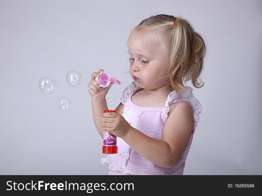 Little girl playing with soap bubbles. Little girl playing with soap bubbles