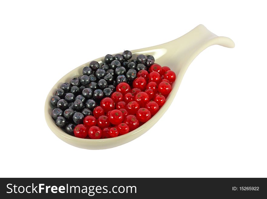 Blueberries and currants in a spoon isolated on white