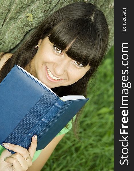 Young beautiful woman in a park with a notebook. Young beautiful woman in a park with a notebook