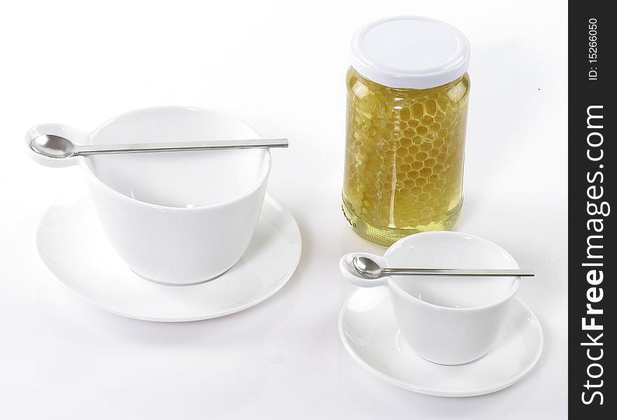 Tea cups and honey on white