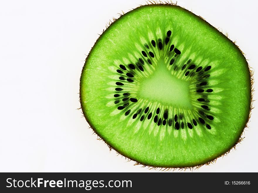 A bright green slice of kiwi with dark seeds and a prickly skin