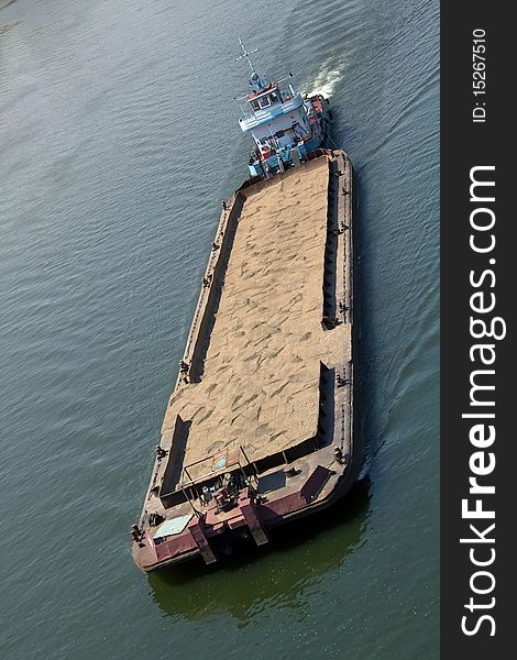 The cargoship for sand transportation floats on the river. The cargoship for sand transportation floats on the river