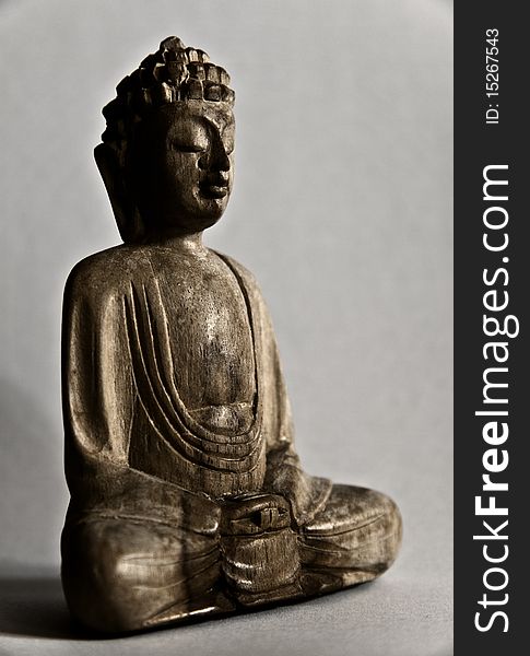 A wooden buddha staue deep in meditation