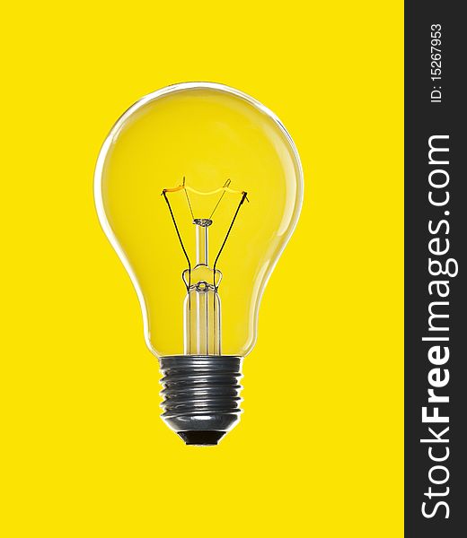 A light bulb over a yellow background. Tungsten glowing filament. A light bulb over a yellow background. Tungsten glowing filament.