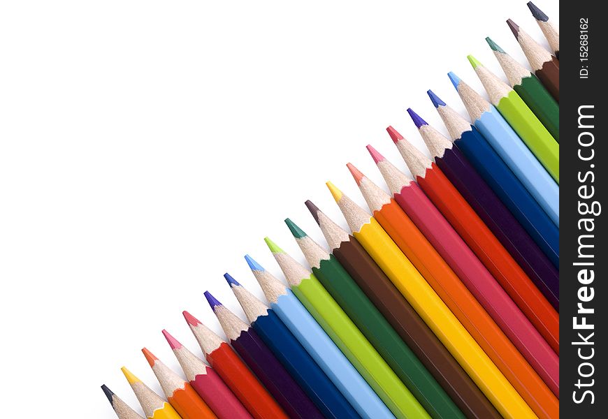 Colored pencils form a diagonal over a white background. Copy space. Colored pencils form a diagonal over a white background. Copy space.