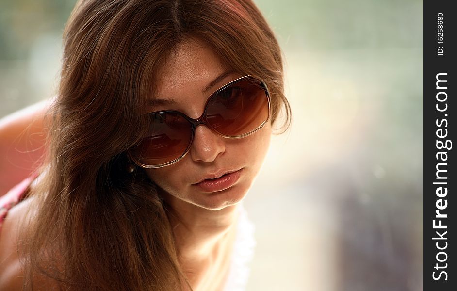 Portrait of young woman with sunglasses, window background