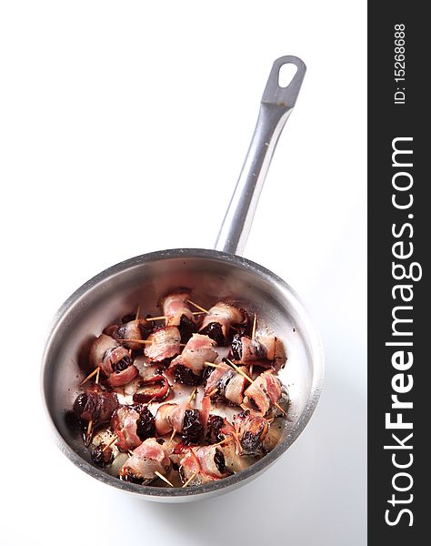 Bacon wrapped prunes in a saucepan - studio