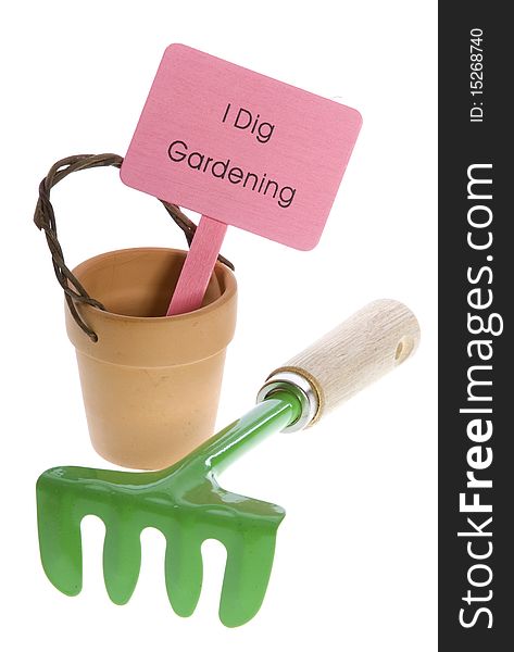 Empty orange clay terra cotta pot with pink sign that says I Dig Gardening with green hand rake in front of it, isolated on white. Empty orange clay terra cotta pot with pink sign that says I Dig Gardening with green hand rake in front of it, isolated on white.