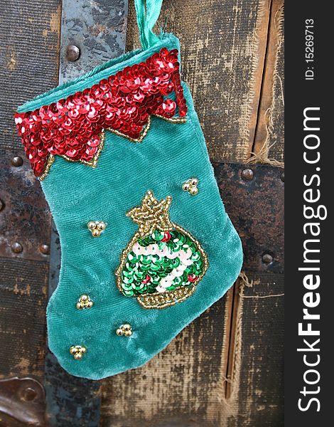 Small Christmas stocking against an antique wooden trunk