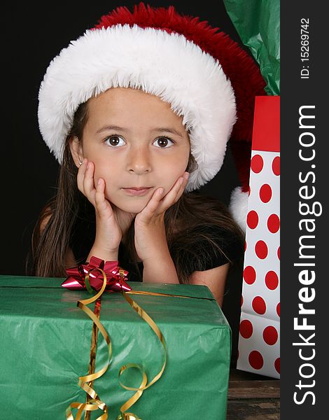 Cute brunette girl sitting amongst christmas gifts