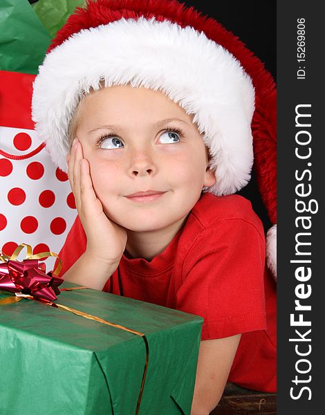 Cute caucasian boy wearing a christmas hat looking up. Cute caucasian boy wearing a christmas hat looking up