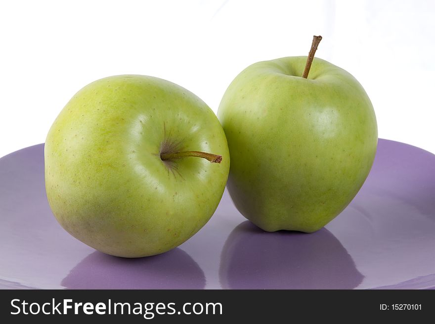 Fresh green apples on the purple plate