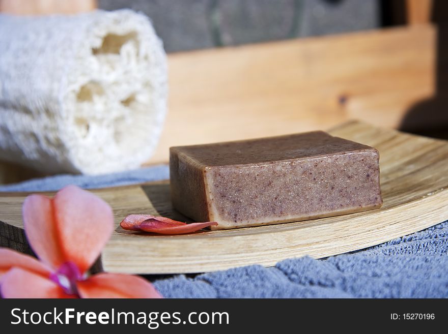 Organic soap on bamboo soap plate with flower and towel