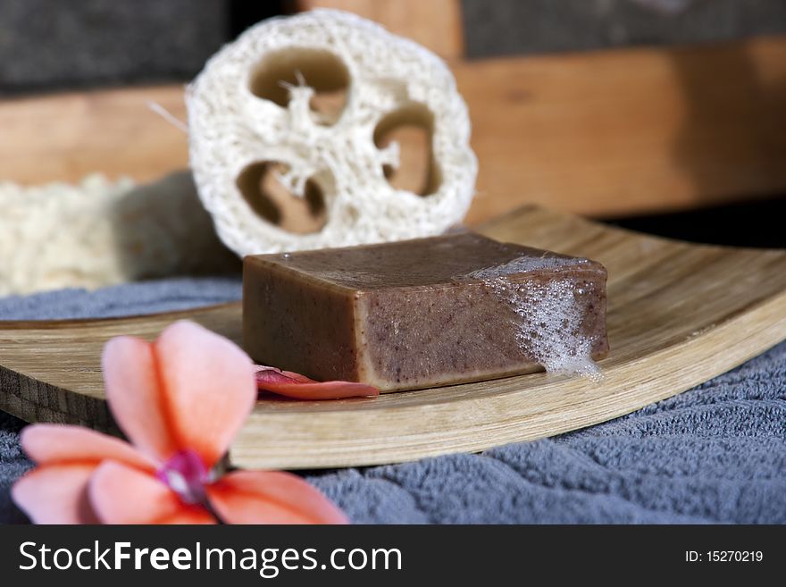 Organic soap with foam on bamboo soap plate with flower and towel