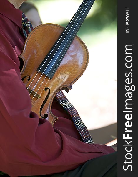 Small violin tucked away in a man's red shirt.