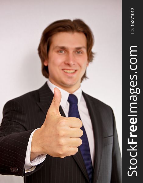 Young businessman showing thumb up. Young businessman showing thumb up