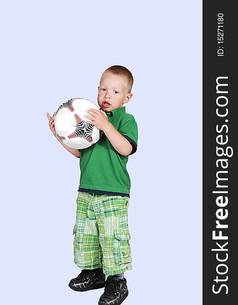 A lovely toddler standing on the floor in the studio holding up a big
soccer ball, on white background. A lovely toddler standing on the floor in the studio holding up a big
soccer ball, on white background.