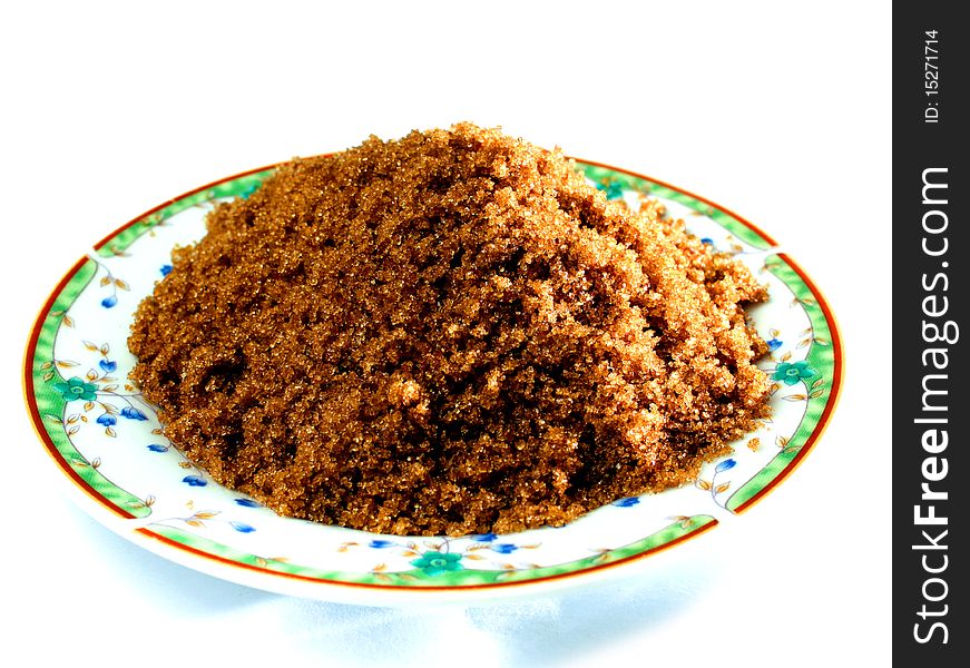 Granulated unrefined brown sugar on a dcorative table plate