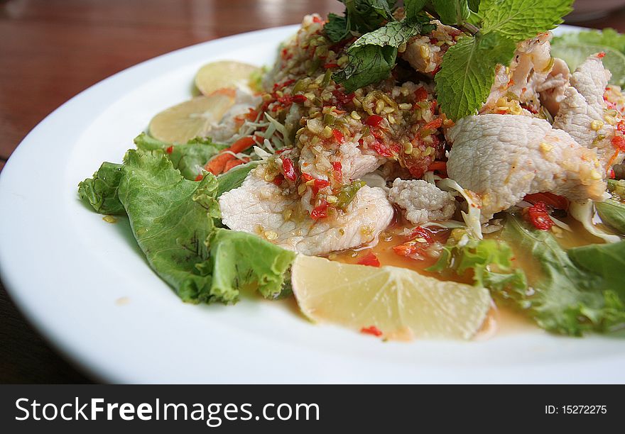 Delicious thai food spicy pork and lemon cooking with peppermint and lettuce in beautiful dish. Delicious thai food spicy pork and lemon cooking with peppermint and lettuce in beautiful dish
