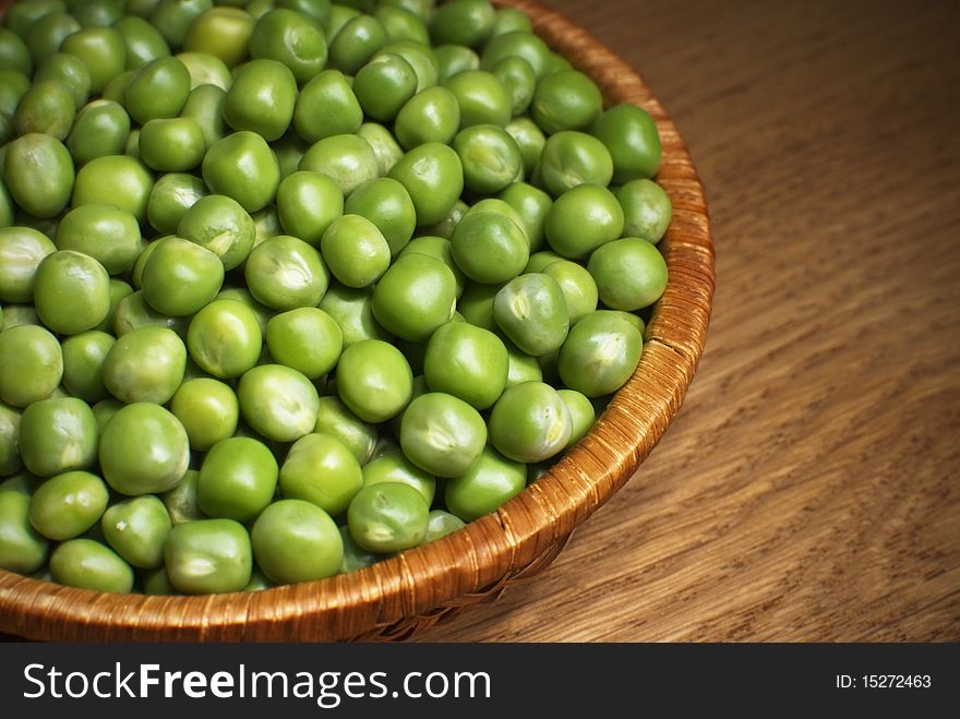 Green peas in the bowl on the table