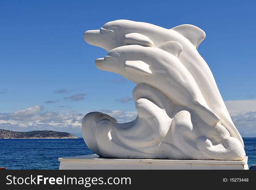 Marble dolphins in port of town Limenas((Thasos) on homonymic island.Greece,Europe.