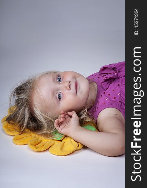 Little girl with her head on a yellow pillow. Little girl with her head on a yellow pillow