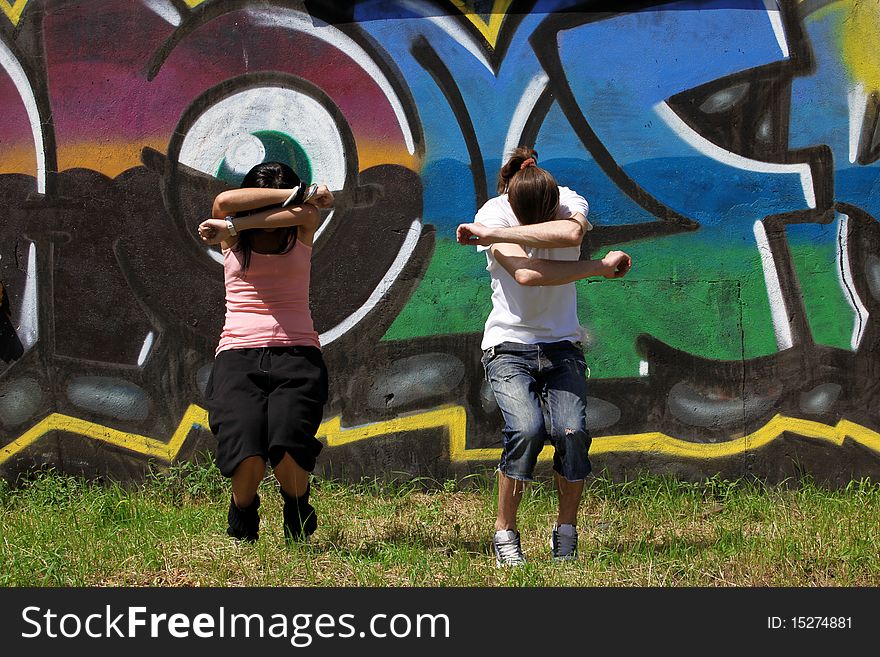 Woman modern dancers in city against graffiti wall