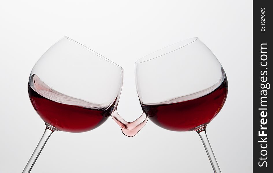 Two wine glasses toasting gesture with splash. Two wine glasses toasting gesture with splash