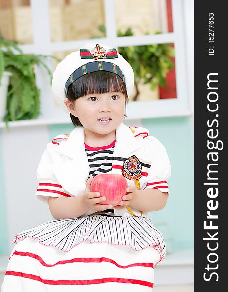 Cute baby girl with a red apple