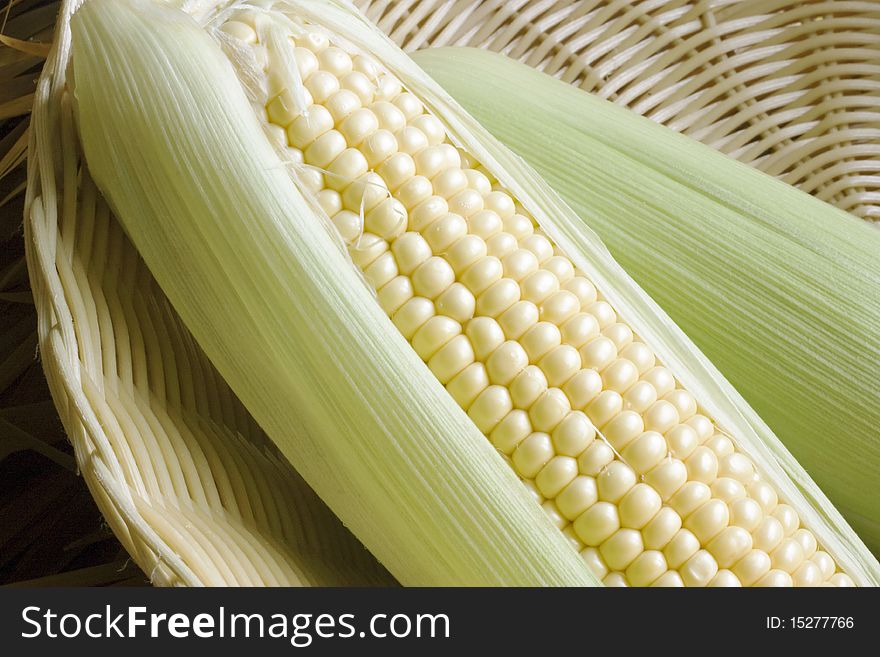 A close up of corn on the cob in a wicker basket. A close up of corn on the cob in a wicker basket