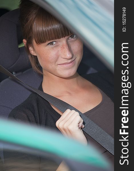 Woman in car holding safety belt