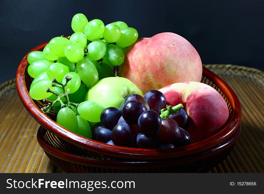 Green grapes, purple grapes,green apple and peach in the technology bamboo tray. Green grapes, purple grapes,green apple and peach in the technology bamboo tray.