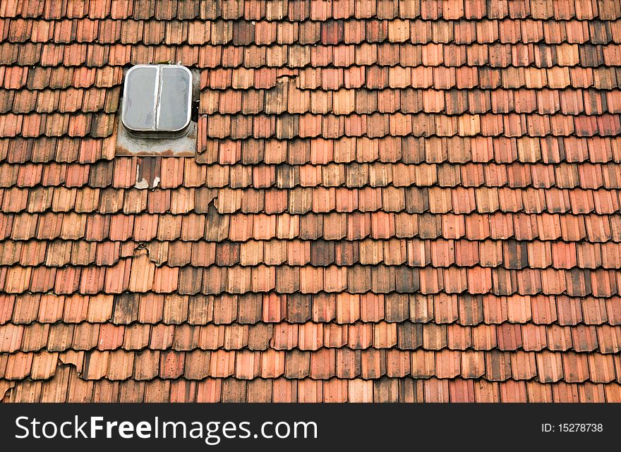 An old roof with a skylight needs renovation. An old roof with a skylight needs renovation