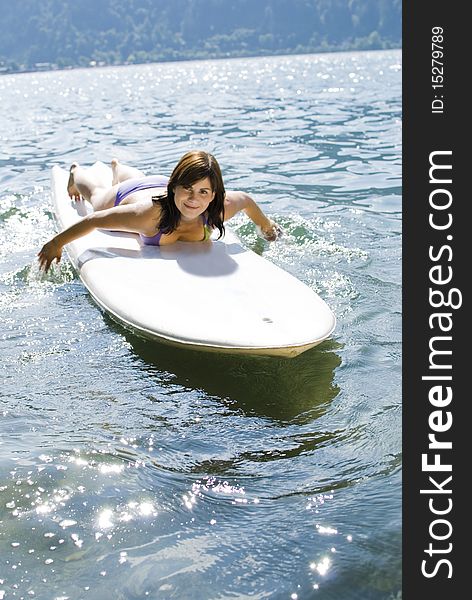 Girl relaxing on surfboard at the lake of Zell am See, Austria. Girl relaxing on surfboard at the lake of Zell am See, Austria