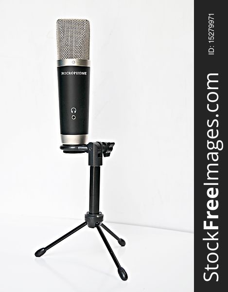 A black professional microphone on tripod isolated on white