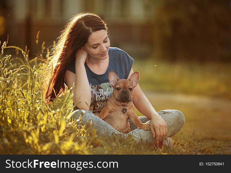 Young woman walking with a french bulldog puppy