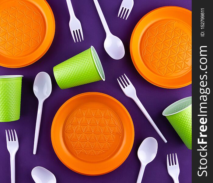 Plastic orange green waste collection on purple background. Concept of plastic pollution and ecology problem.