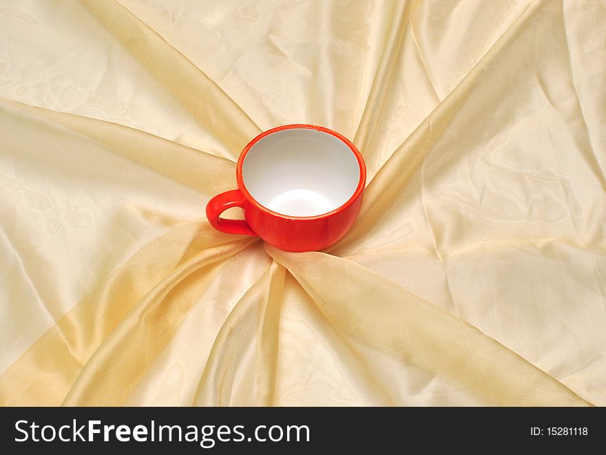 Photo of single red cup at the golden fabric drapery