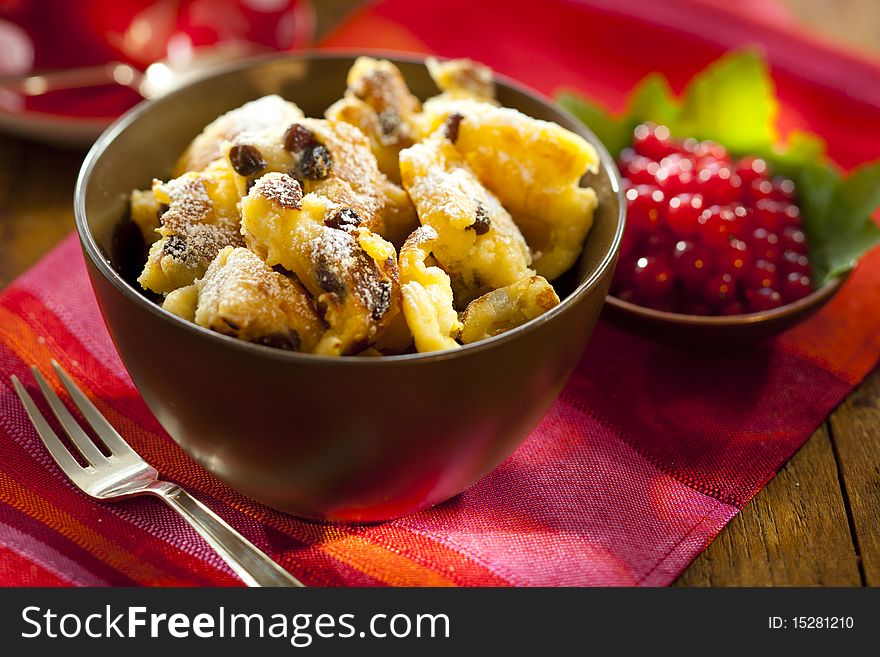 Cut-up and sugared pancake with raisins and red currants