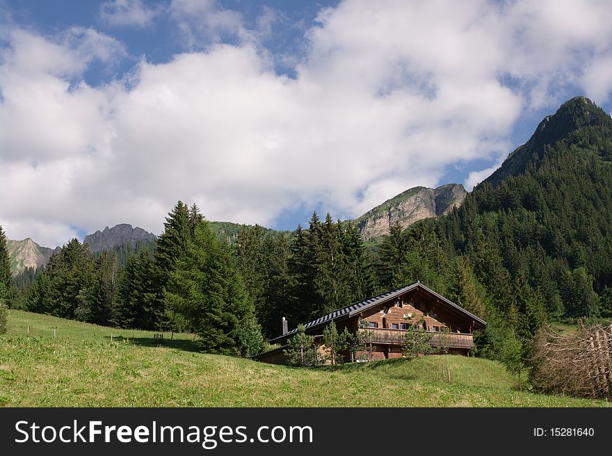 Summer landscape with swiss mountains, meadow and traditional wooden house. Summer landscape with swiss mountains, meadow and traditional wooden house