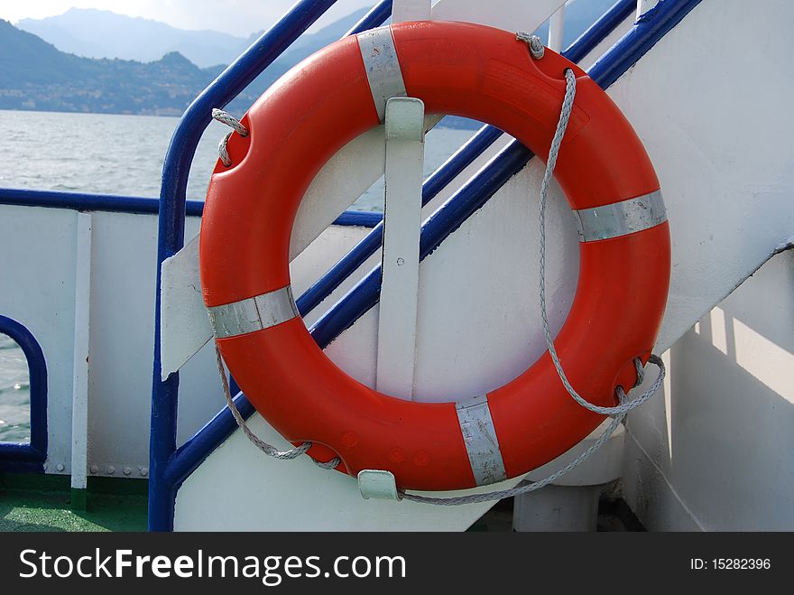 Orange lifebuoy ring attached to a ship deck. Orange lifebuoy ring attached to a ship deck